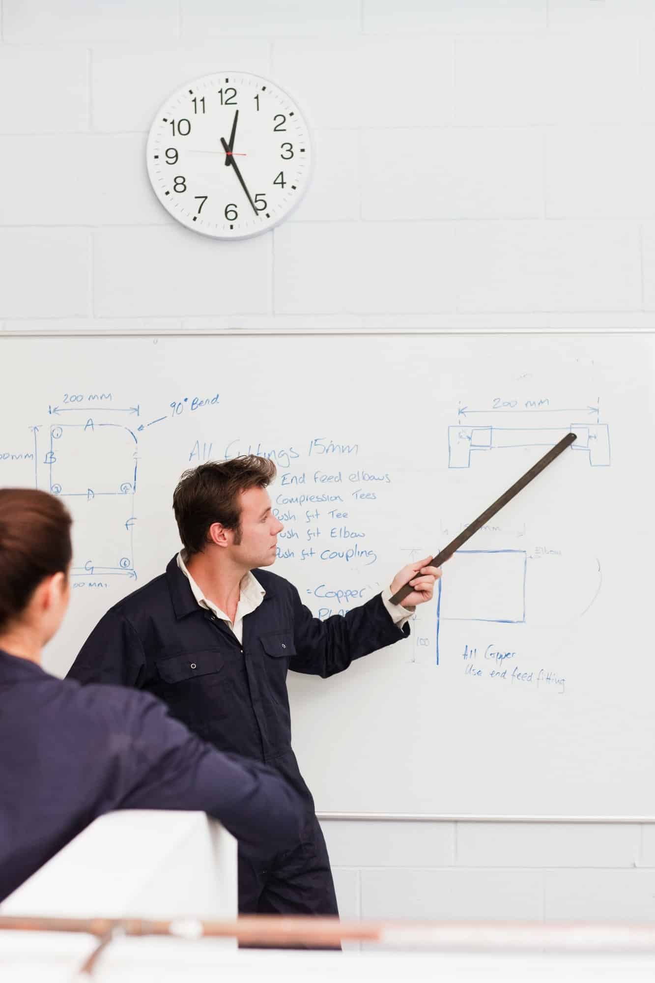 Professeur qui explique un cours sur un tableau blanc